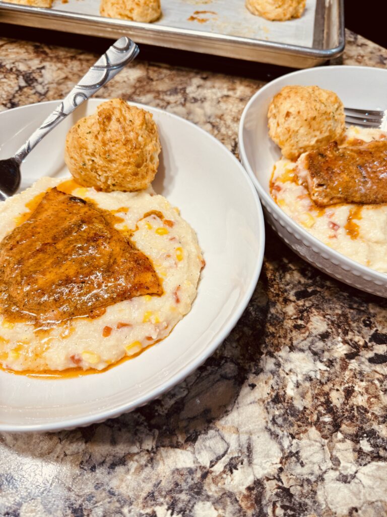 Creamy confetti grits topped with salmon and savory Old Bay butter