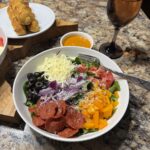 Pizza salad with pepperoni, peppers, cheese, and sun dried tomato vinaigrette