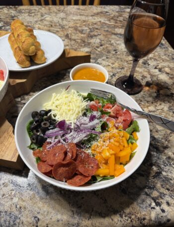 Pizza salad with pepperoni, peppers, cheese, and sun dried tomato vinaigrette